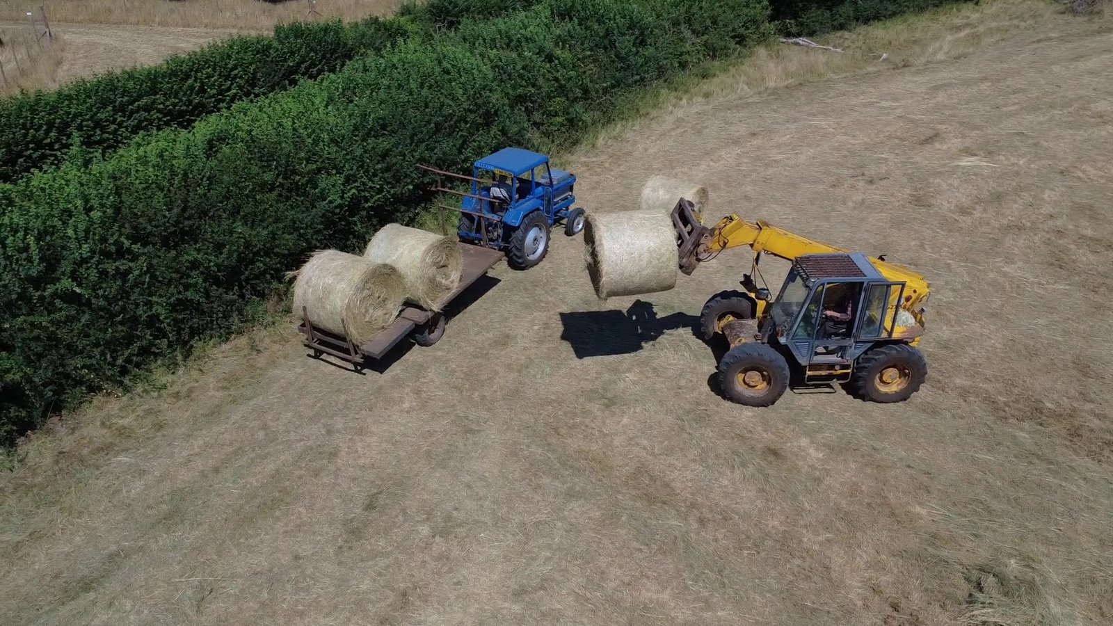 Aerial view of electric Leyland collecting hay bales